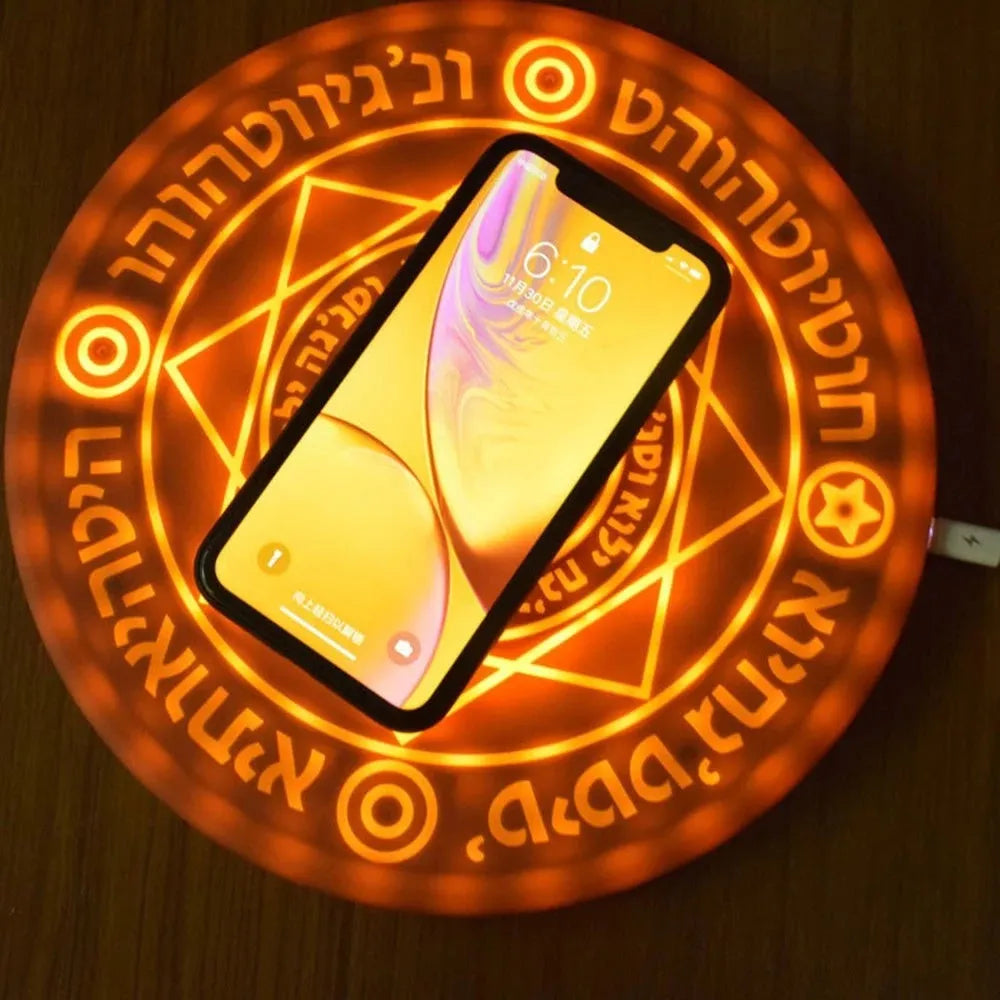 Square black wireless charging pad with illuminated magic array pattern, shown with a smartphone on top.