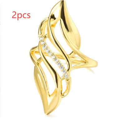 Gold tone exaggerated curve copper ring with zircon stone on white background