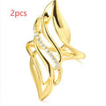Gold tone exaggerated curve copper ring with zircon stone on white background