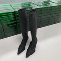 Black women's below-the-knee pointed toe stiletto boots with a back zipper on a white background
