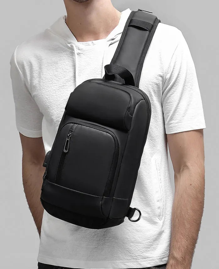 Black PVC outdoor shoulder bag showing computer pocket, air cushion strap, and square vertical design