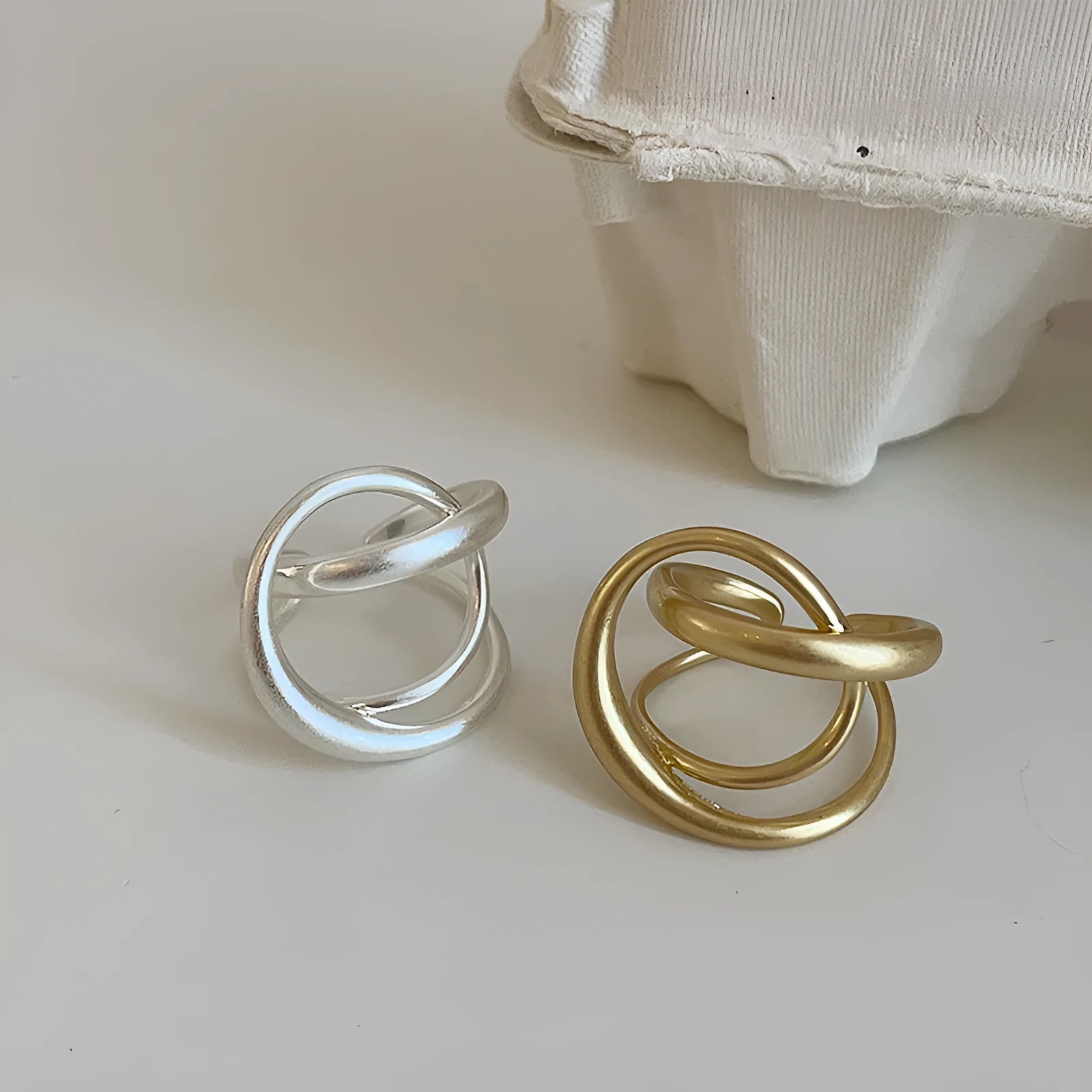 Geometric open ring with three-dimensional interlaced design in matte metal