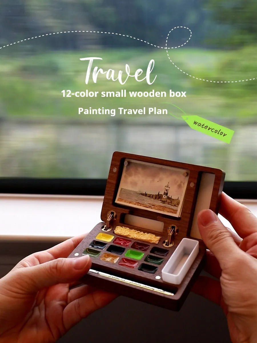 Mini wooden watercolour paint box open to show compartments filled with professional artist pigments.