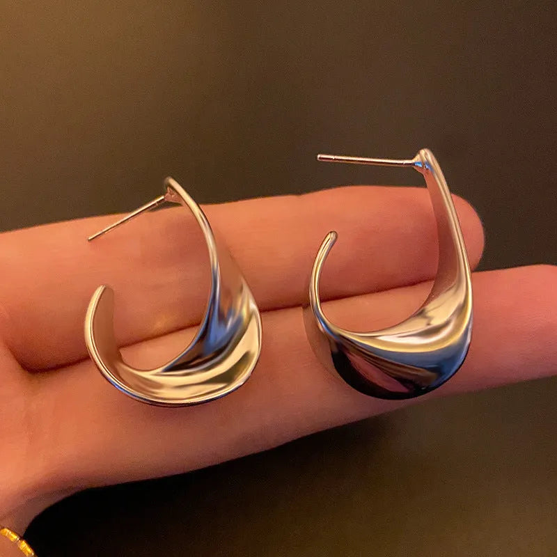 Gold twisted geometric metal earrings with round design elements