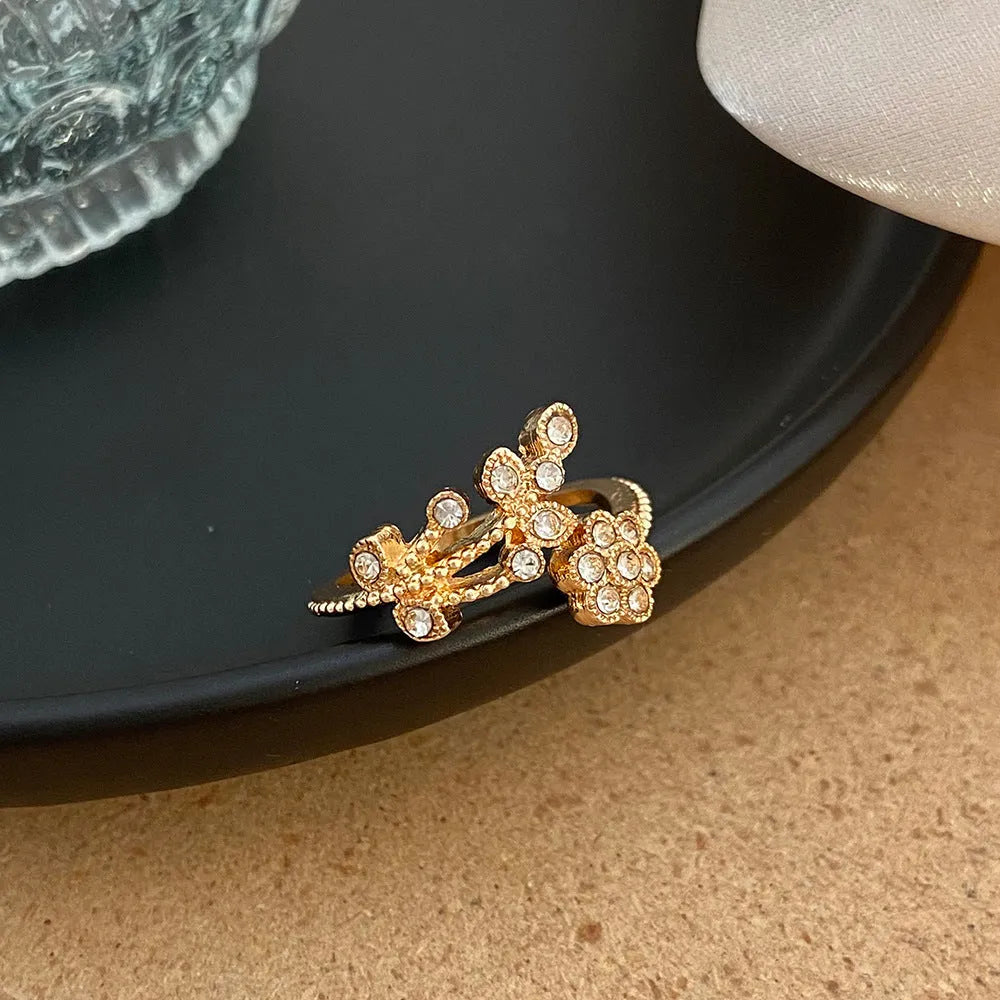 Open mouth copper ring with flower and leaf design in gold finish