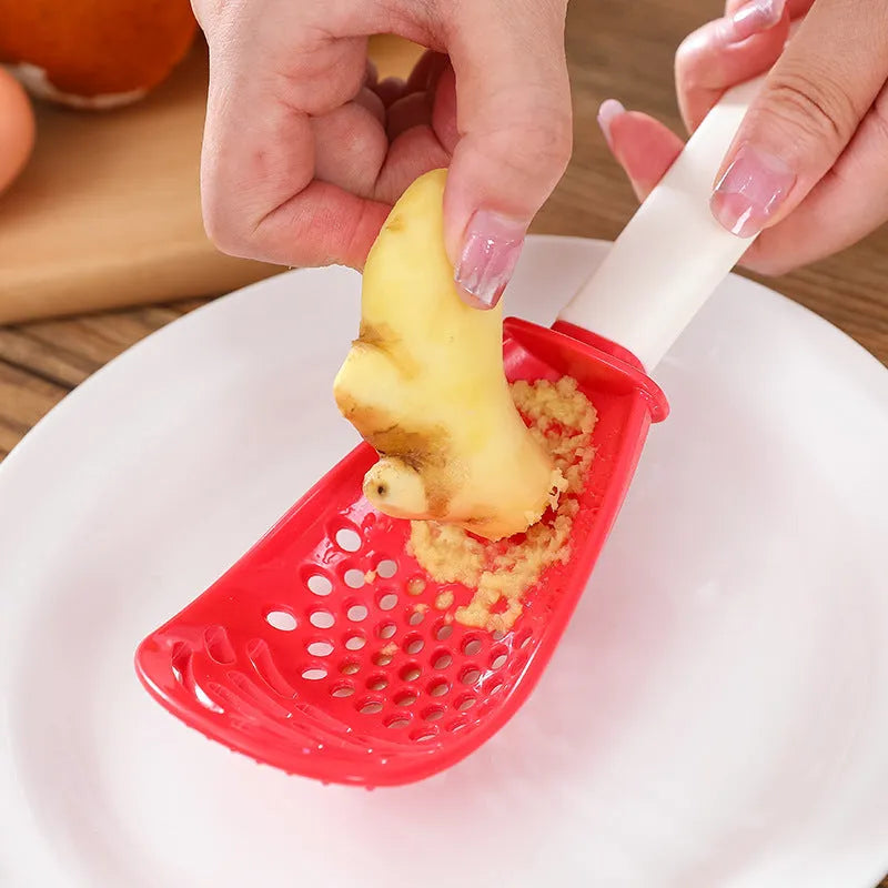 Multifunctional slotted cooking spoon in red plastic with serrated edge and half-enclosed head for scooping rice