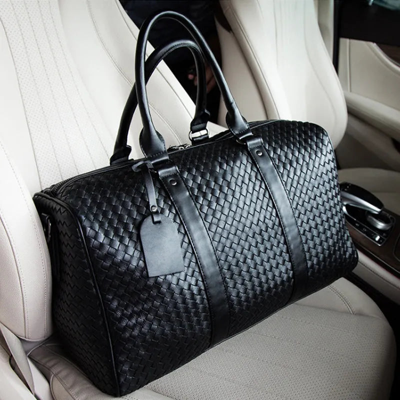 Black handwoven PU leather shoulder bag, medium size, zip closure, tie-rod fitting, on beige background
