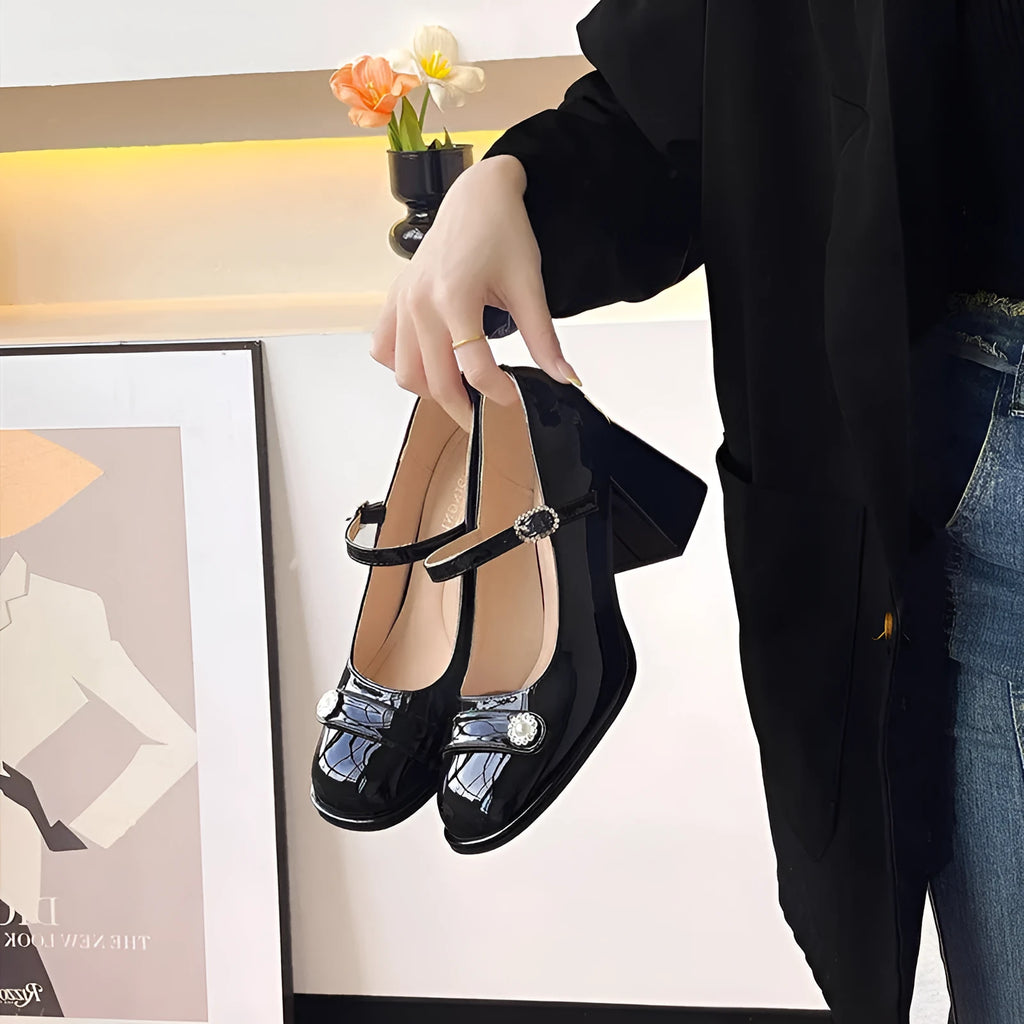Women's black patent leather wide fit high heels with a round toe and chunky heel.