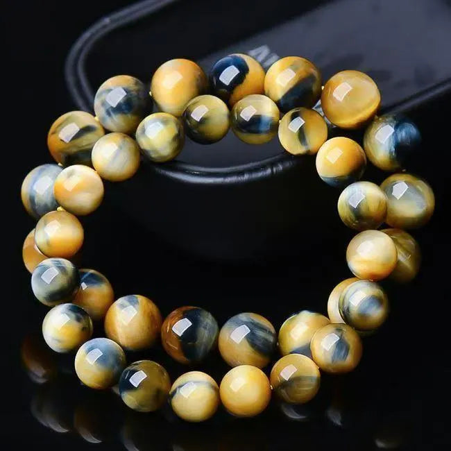 A fantasy tigereye agate bracelet with round geometric beads on a wrist.