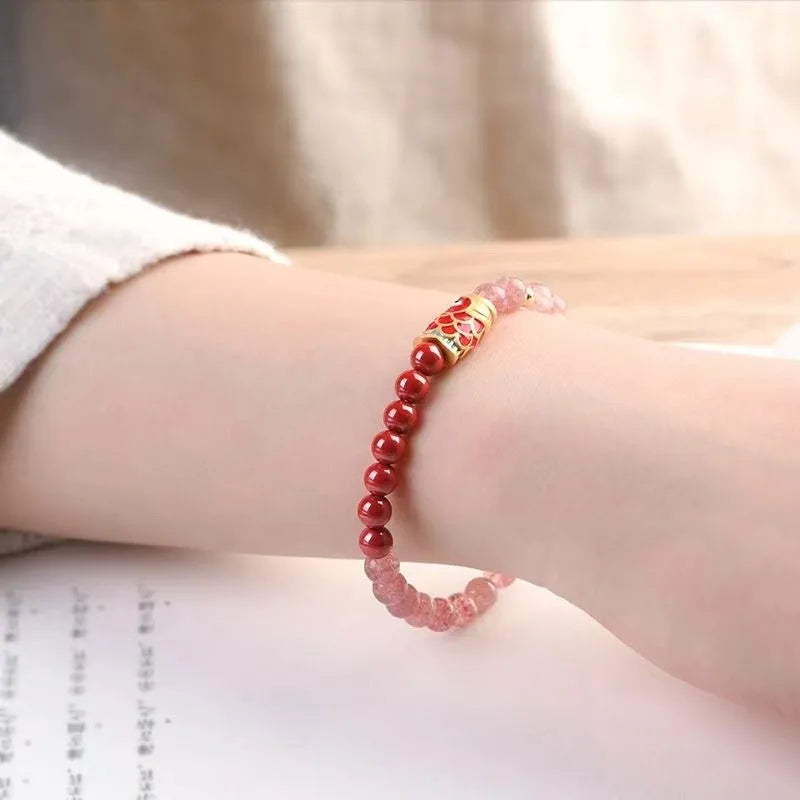Close-up of a women's bracelet with purple cinnabar and pink strawberry quartz beads in a retro design.