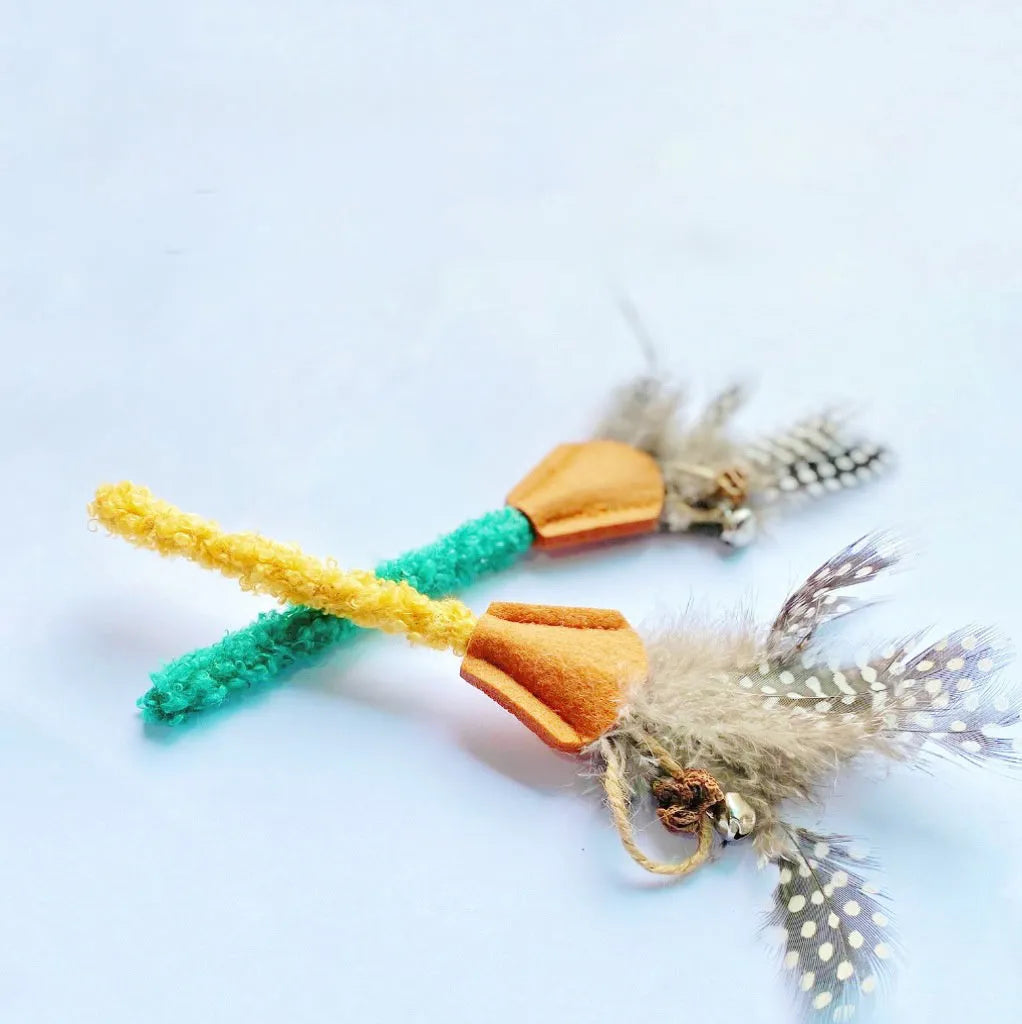 Green polygonum wood feather stick cat toy with gall fruit accent on white background