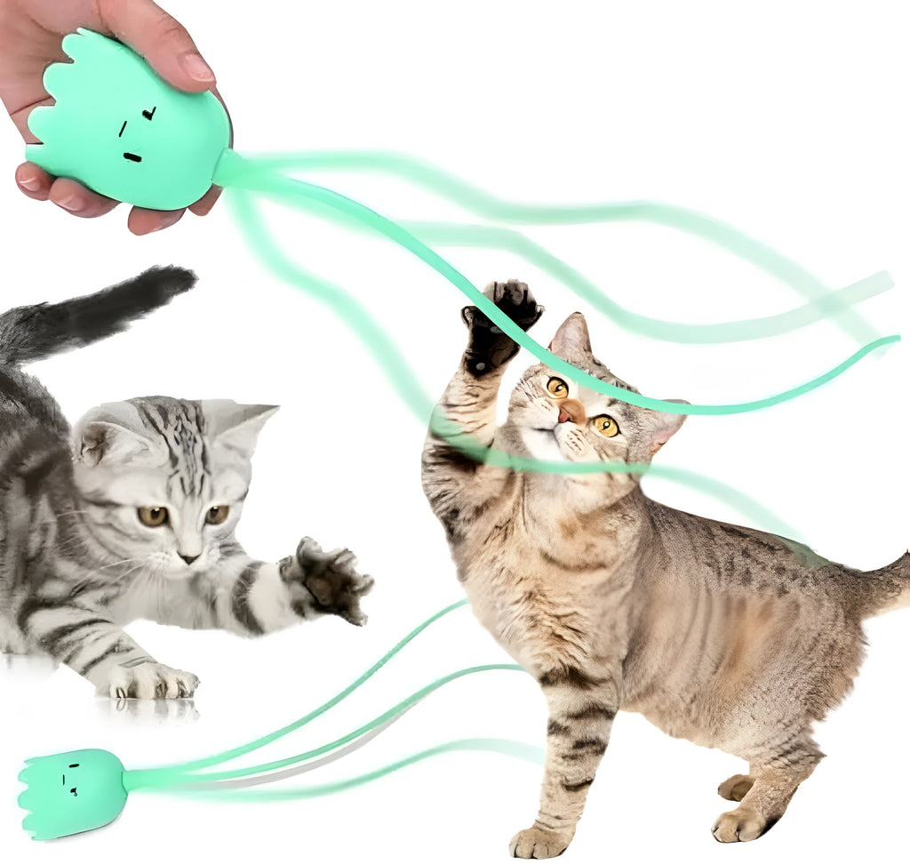 Green automatic electronic cat wand toy with a swinging silicone tail on a wooden floor.