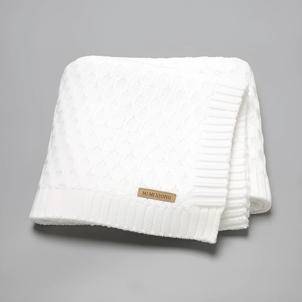 Solid colour acrylic baby blanket with textured lines, shown in a neutral shade, dimensions 70x90 cm