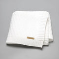 Solid colour acrylic baby blanket with textured lines, shown in a neutral shade, dimensions 70x90 cm