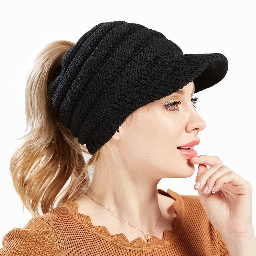 A soft grey acrylic knitted beanie for women, worn over a ponytail.