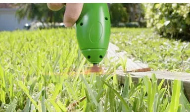 Cordless lawn trimmer weed trimmer with extension pole and debris shield on green grass