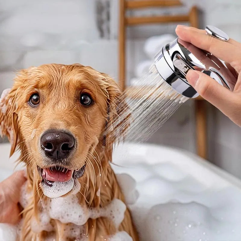 Silver dog shower attachment with soft silicone comb teeth and ergonomic grip on a white background