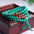 Multi-layer turquoise bracelet with 108 round polished beads in 6mm size on plain background