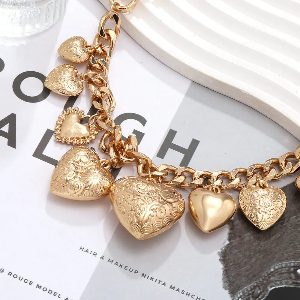 Carved heart-shaped pendant necklace on an adjustable metal chain in gold colour.