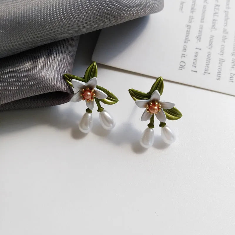 Silver colour needle camellia flower earrings showing stud and clip-on styles.