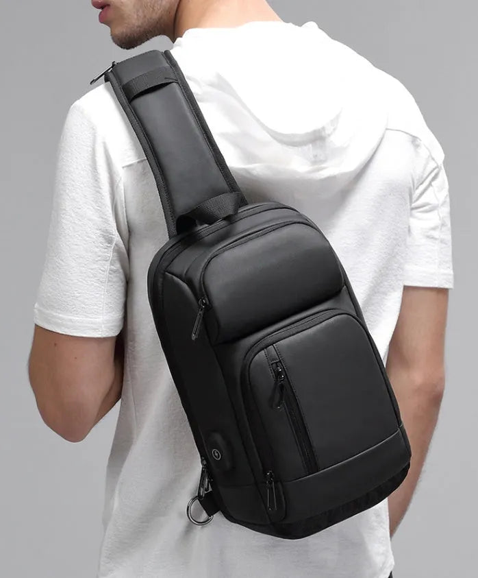 Black PVC outdoor shoulder bag showing computer pocket, air cushion strap, and square vertical design