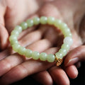 Green jade bracelet with vintage beads on white background, ethnic style women's jewellery