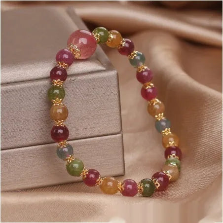 Natural tourmaline and strawberry quartz 10mm round bead unisex bracelet on neutral background