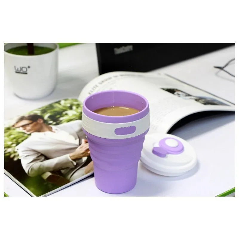 Collapsible silicone travel cup in pink folded to 6cm height with anti-hot handle and leak-proof lid