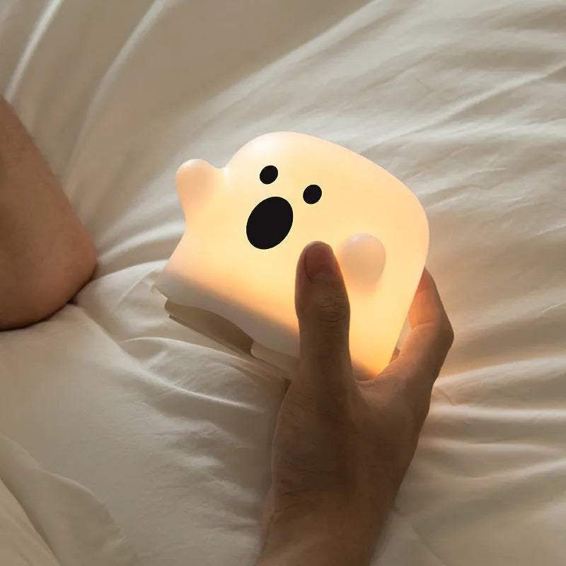 Silicone night light in Ah Ah style on a bedside table with soft glow