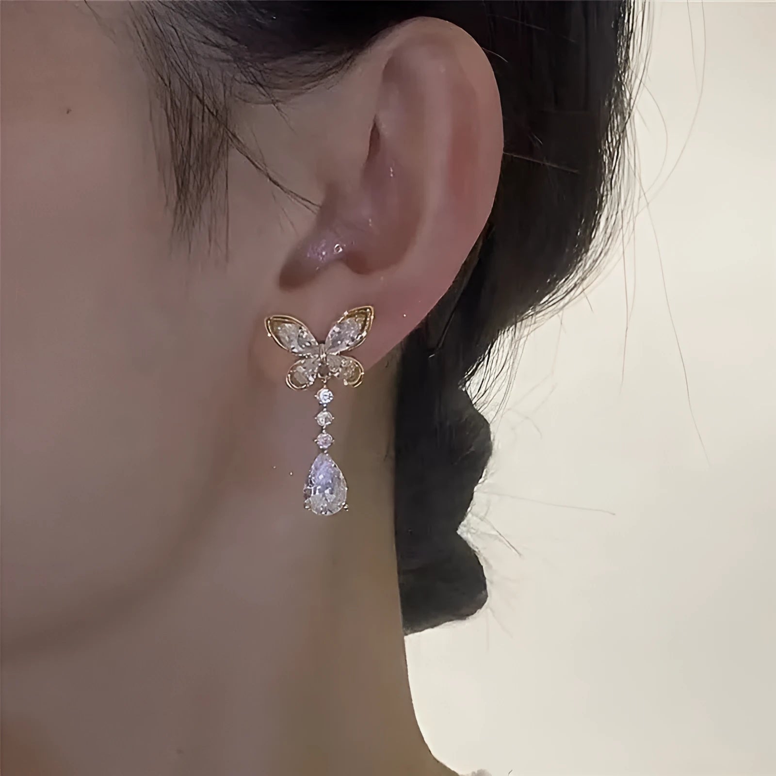 Pair of zinc alloy bow stud earrings with electroplated platinum finish on a white background