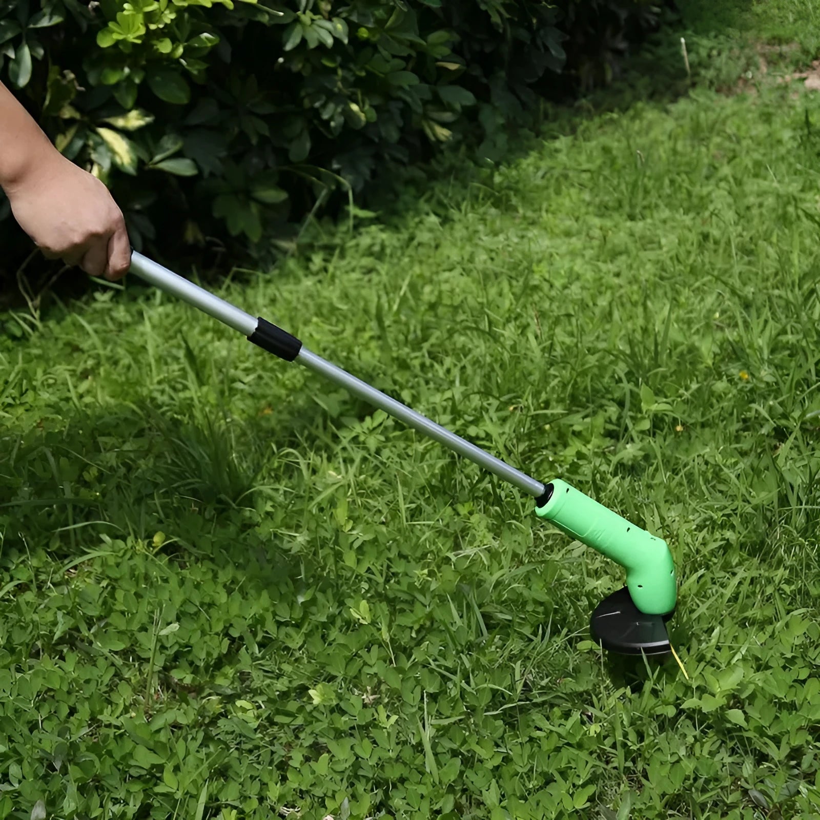 Cordless lawn trimmer weed trimmer with extension pole and debris shield on green grass
