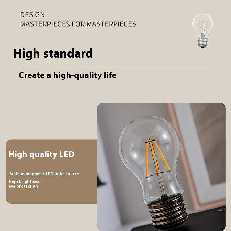 Small black suspension bulb night lamp with iron art body on a wooden base.