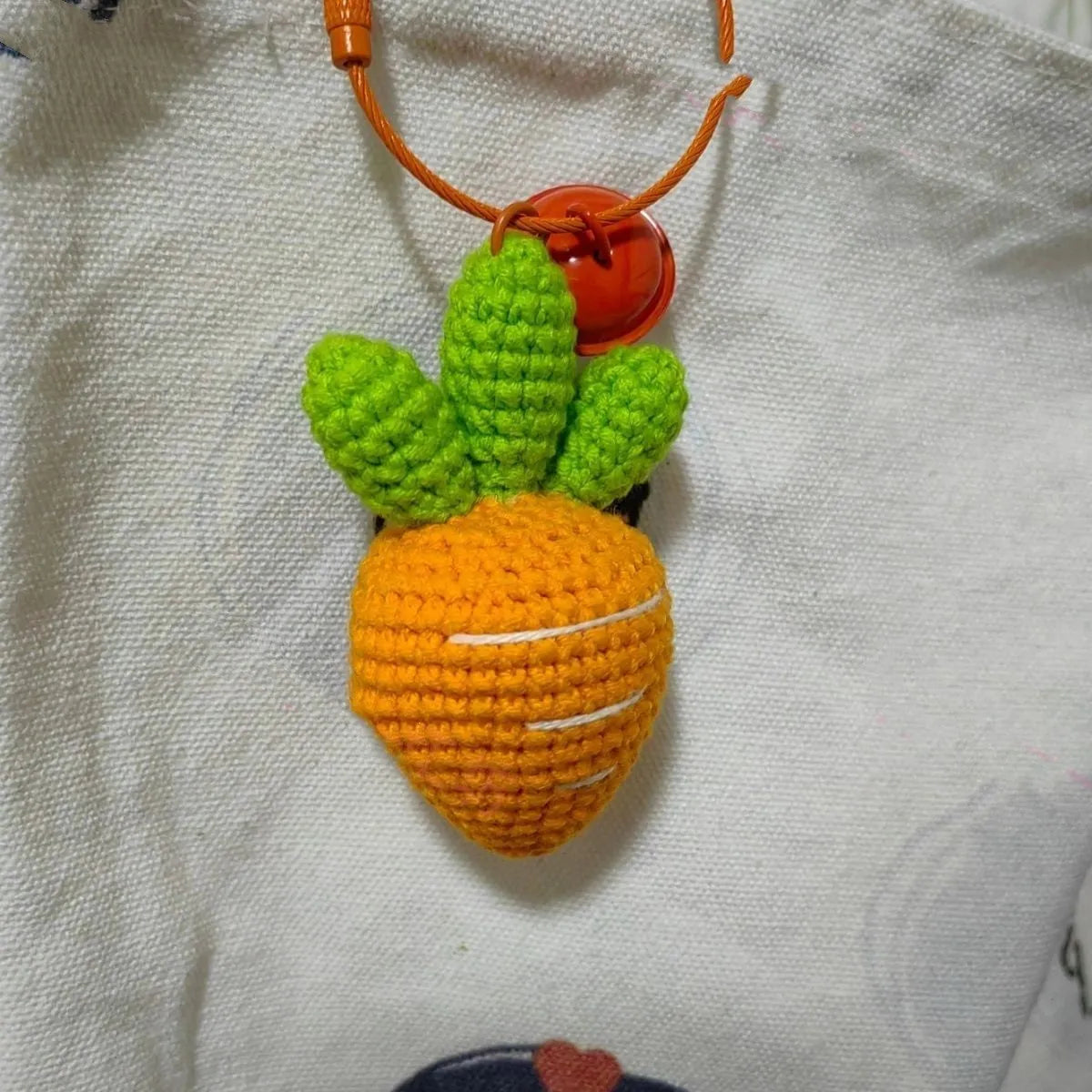 Orange and green carrot keychain pendant made from wool, shown on a key ring