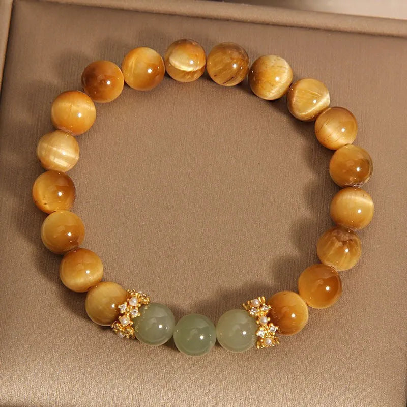Natural yellow tiger's eye bracelet with U-shaped design showing auspicious patterns and traditional symbolic charms