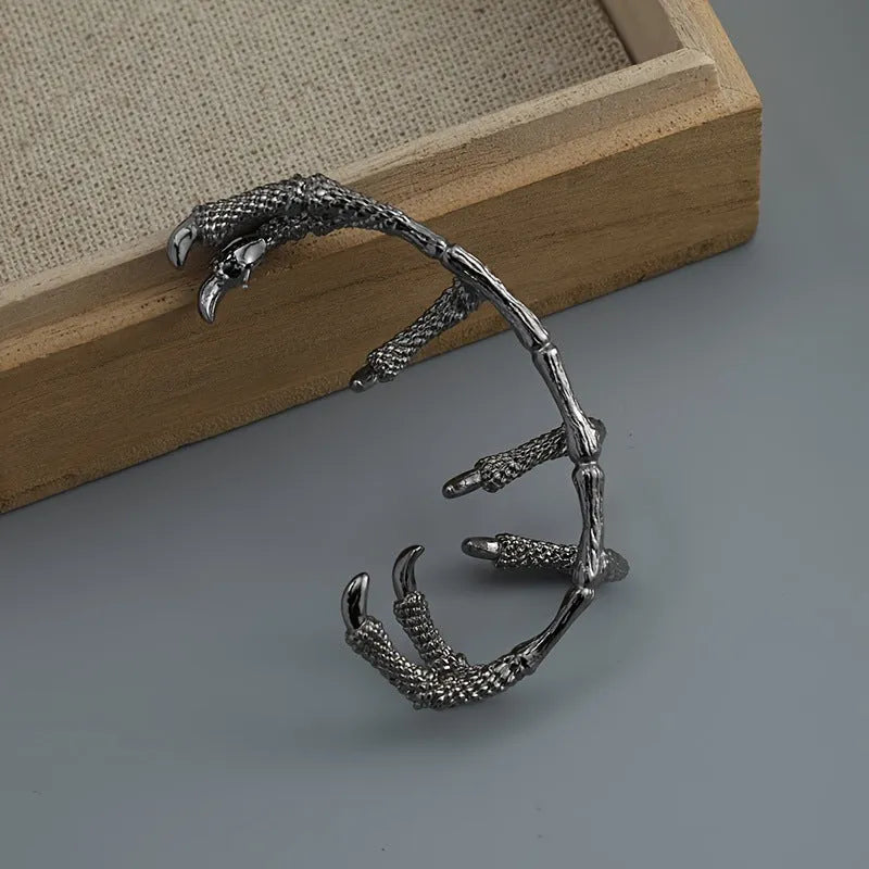 Black copper ear studs with street punk style electroplated finish on a plain background
