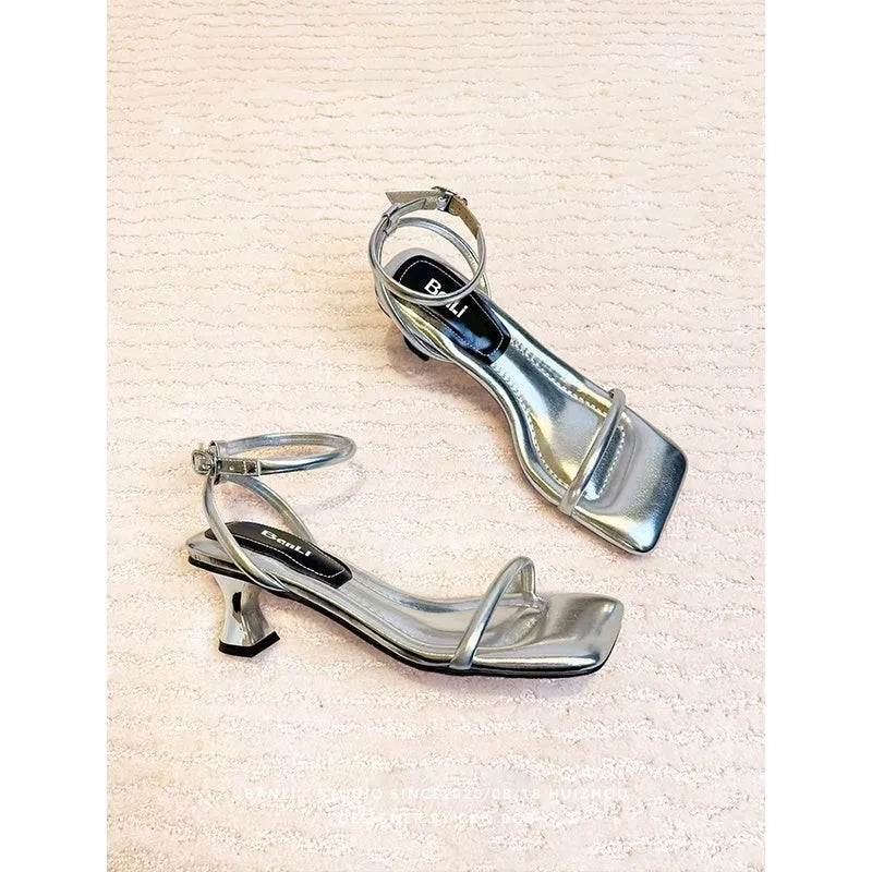 Black square toe high heel sandals with thick heel and one-line buckle strap on a white background