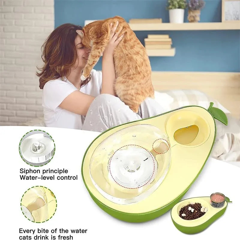 Avocado-shaped automatic water pet feeder with a green water reservoir and a pink slow food bowl on a white surface
