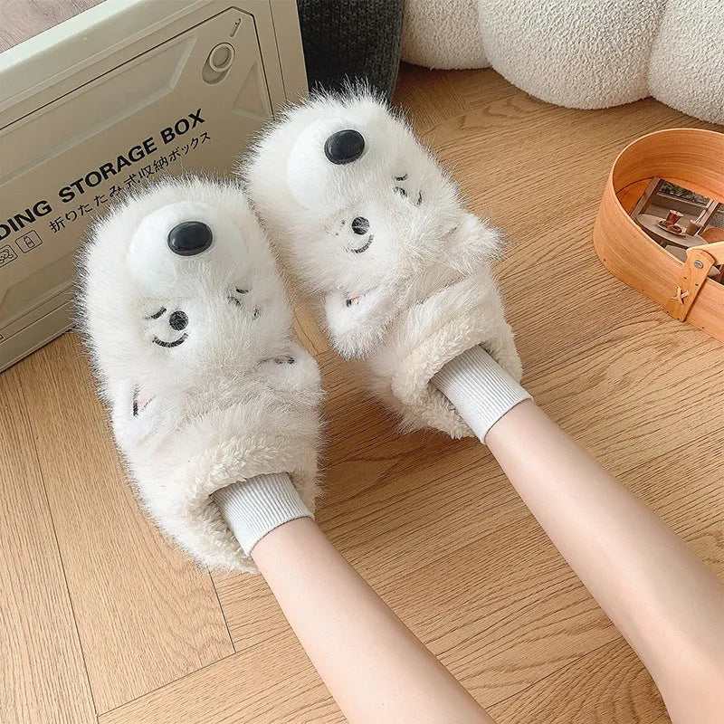 Pair of grey ankle wrap cotton slippers with plush upper and artificial wool lining on a home floor