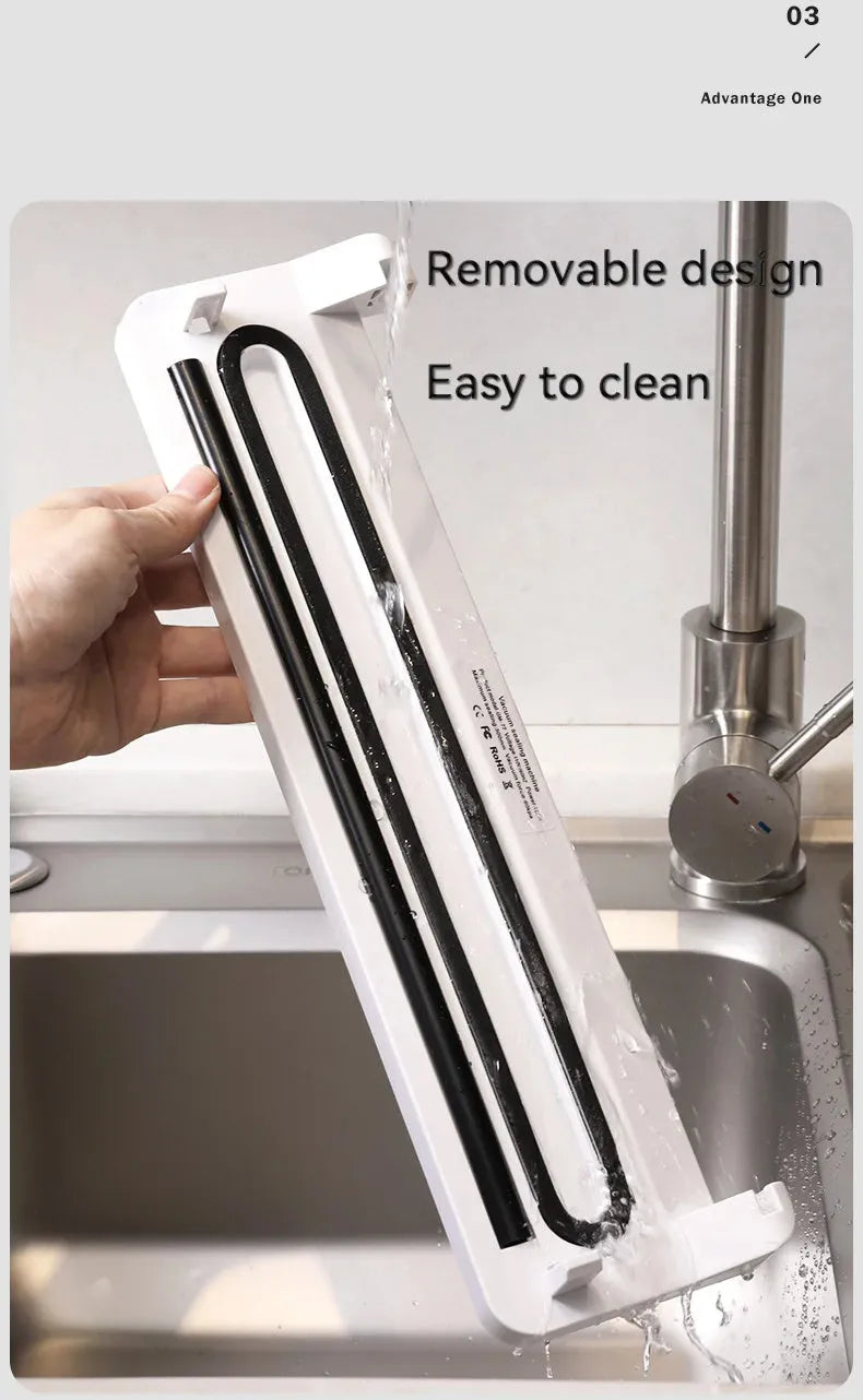 Black compact automatic vacuum sealer machine for food preservation on a kitchen counter.