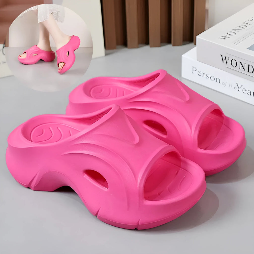 Women's thick-soled EVA slippers in rose red, white and black colours on a beach background.