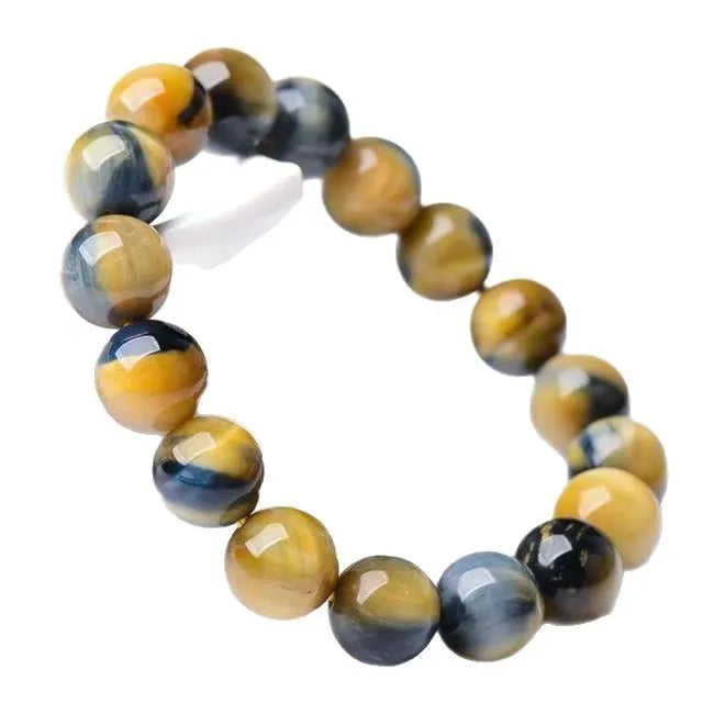 A fantasy tigereye agate bracelet with round geometric beads on a wrist.