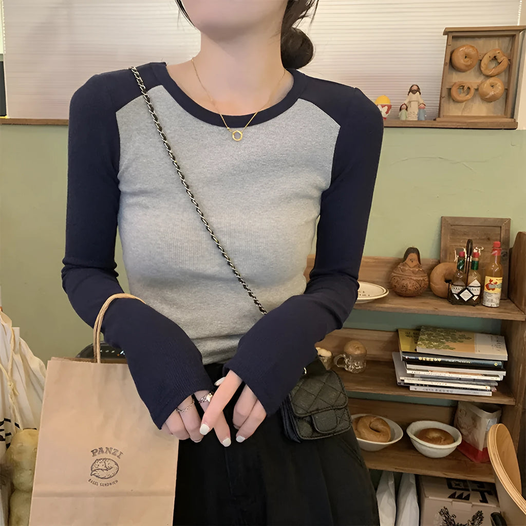 Dark blue oversized women's casual top with long princess sleeves and embroidery detail on a hanger.