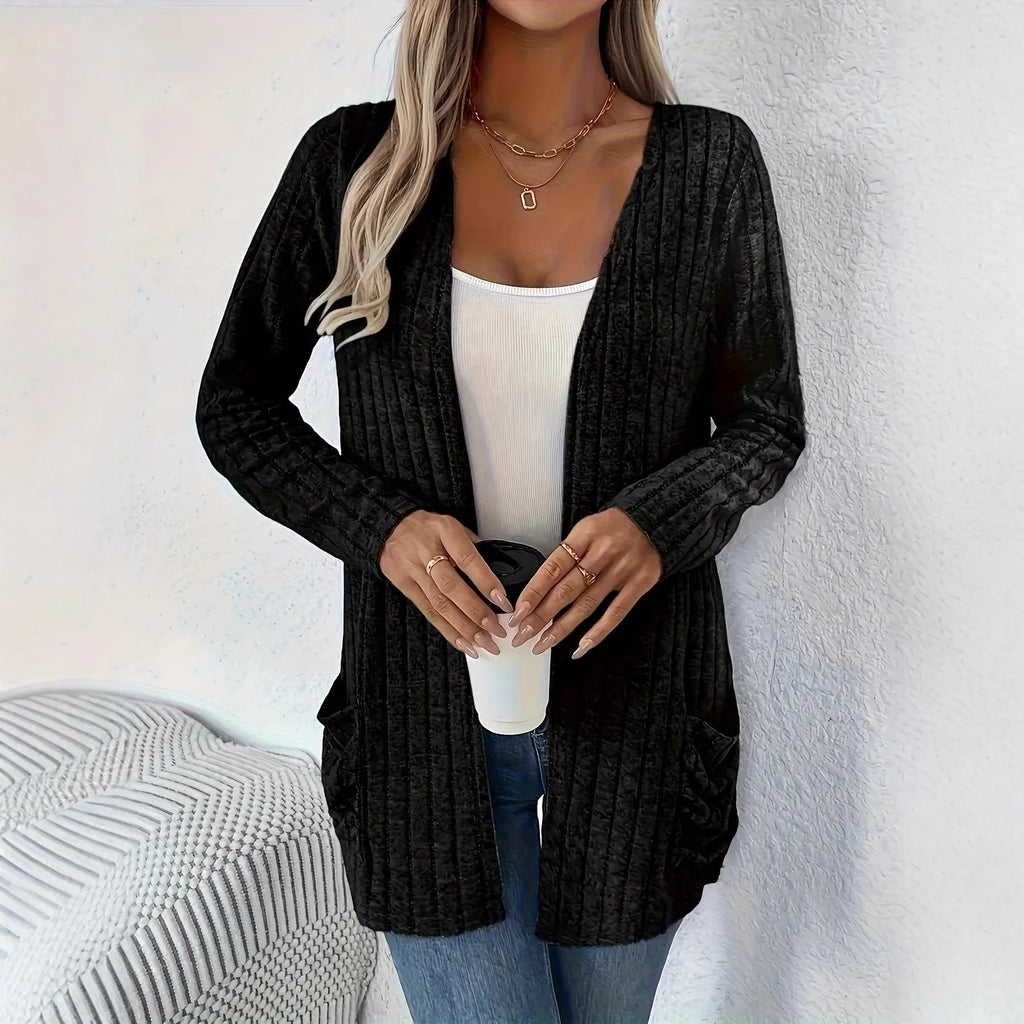 Man wearing a solid grey loose-fit long sleeve cardigan with side pockets.