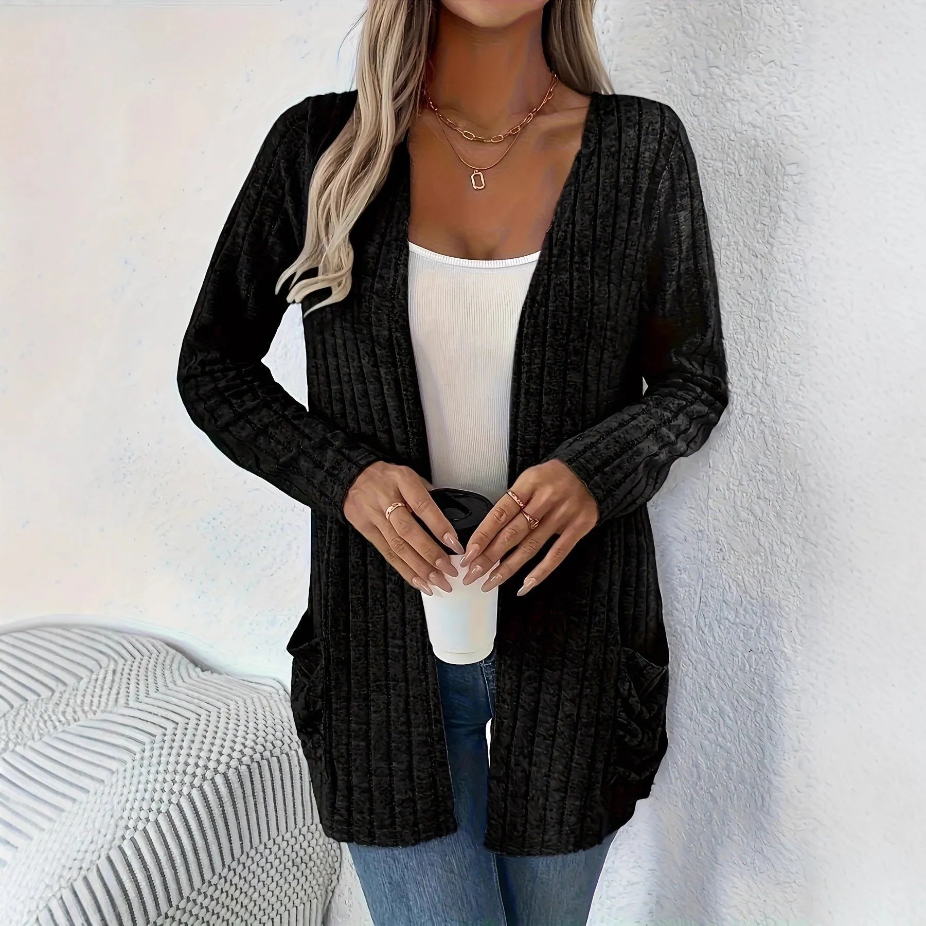 Man wearing a solid grey loose-fit long sleeve cardigan with side pockets.
