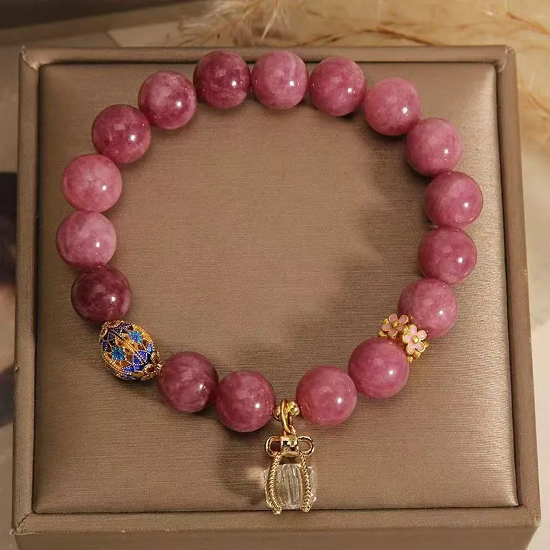 Natural stone beaded bracelet with pink lotus tassel, pearl pendant, and electroplated crystal beads on white background