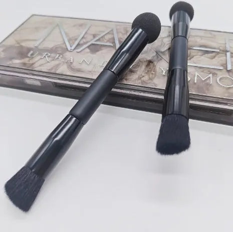 Double-headed black makeup brush with angled sponge and concealer brush on wooden handle