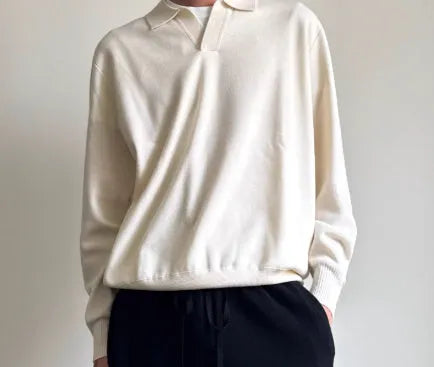 Man wearing a milky white pure wool polo sweater with a lapel collar.