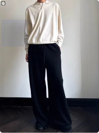 Man wearing a milky white pure wool polo sweater with a lapel collar.