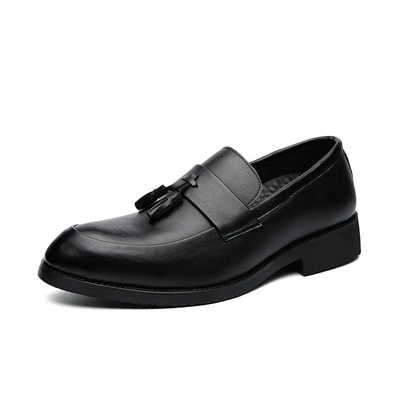 Men's black slip-on business casual shoes with a tassel detail and pointed toe on a rubber sole.