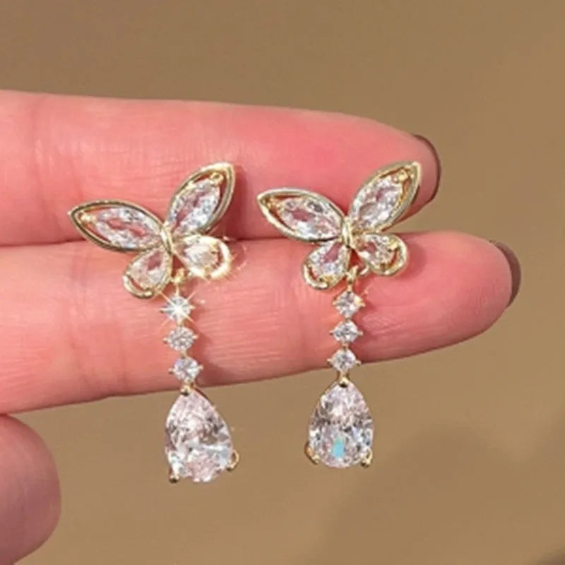 Pair of zinc alloy bow stud earrings with electroplated platinum finish on a white background